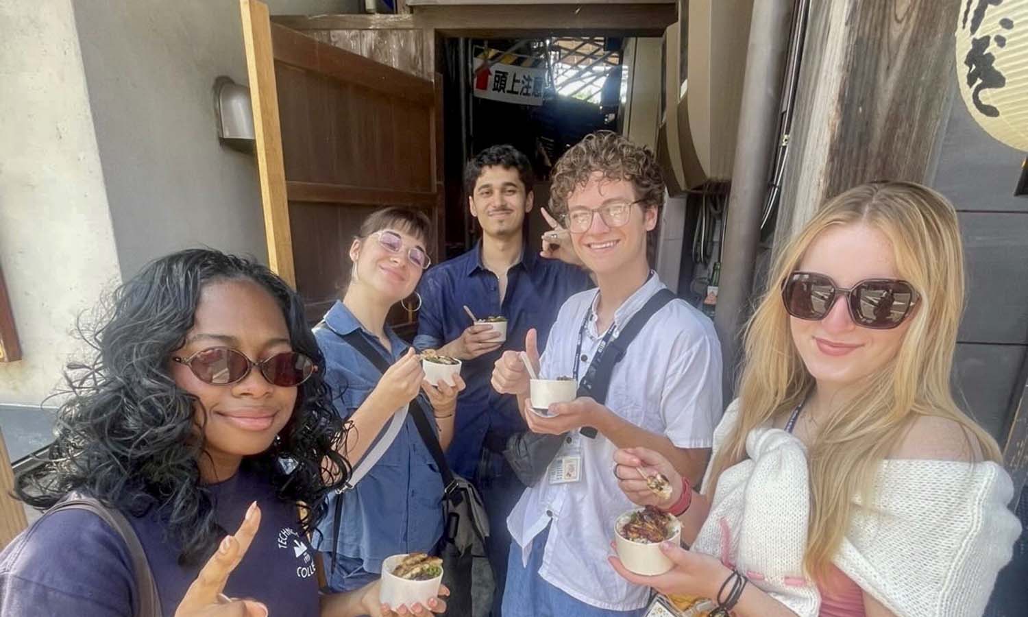 While participating in the intensive language and cultural exchange program at Technos International College in Tokyo, Japan, Roland Gardner-Olesen ’29 and Caroline Lyddane ’28 (fourth and fifth from left) enjoy Unaju, a dish local to Kawagoe. 
