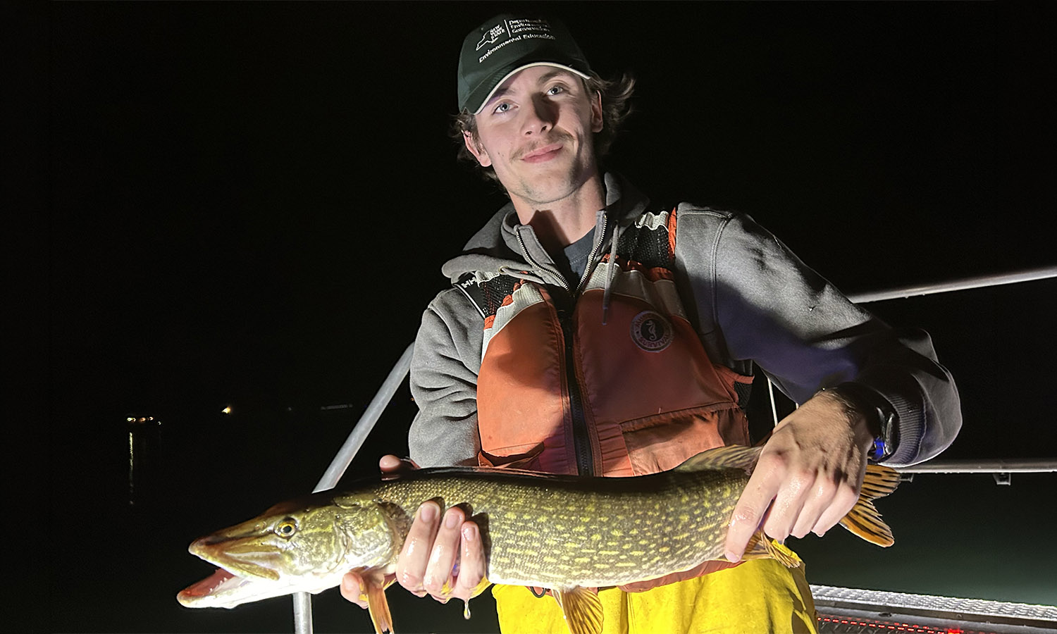 New York State Department of Environmental Conservation intern Connor Visingard ’27 poses for a photo during a night shocking survey on Seneca Lake.  