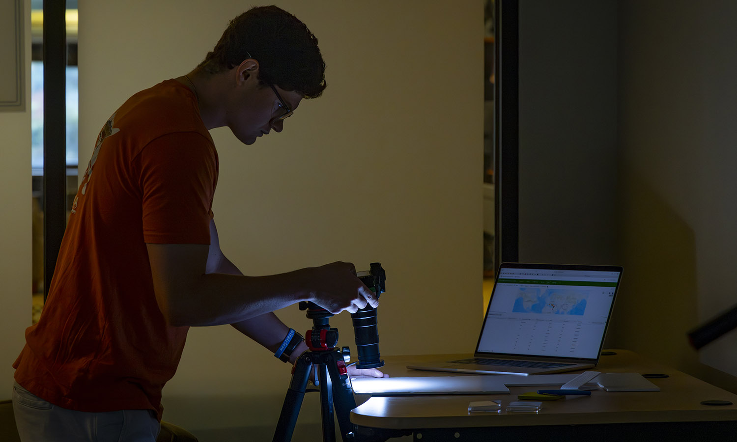 Christian Kneaskern '28 photographs an ancient coin while working with Associate Professor of Greek and Roman Studies Jim Capreedy. 