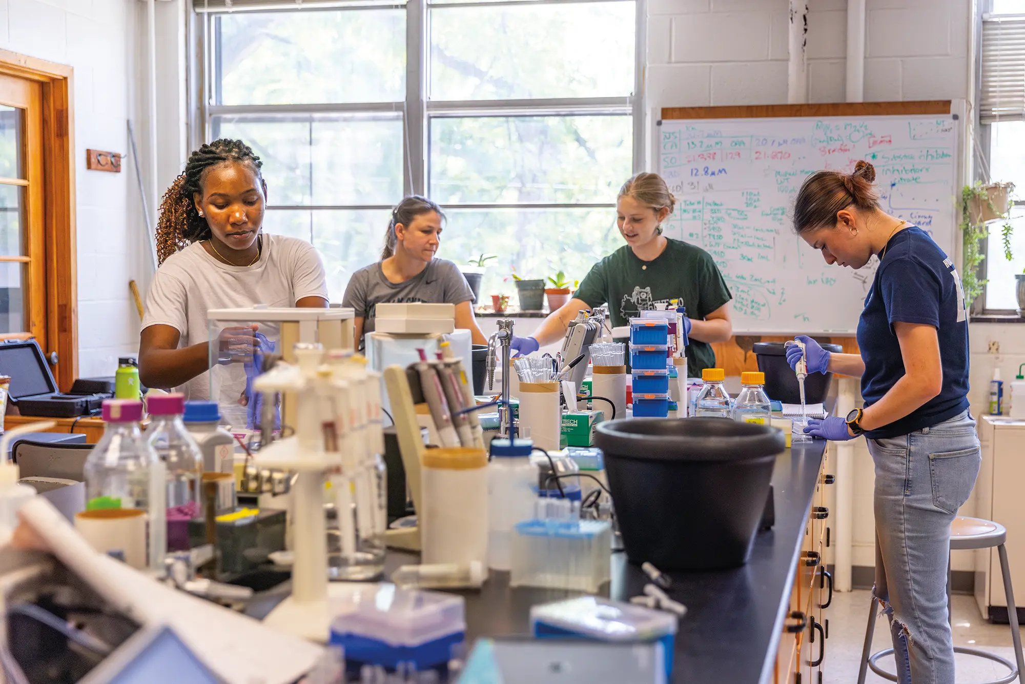 Selina Owino '28, Catherine Antoulinakis '28 and Nora Smith '27 in the chemistry lab with Professor Kristin Slade