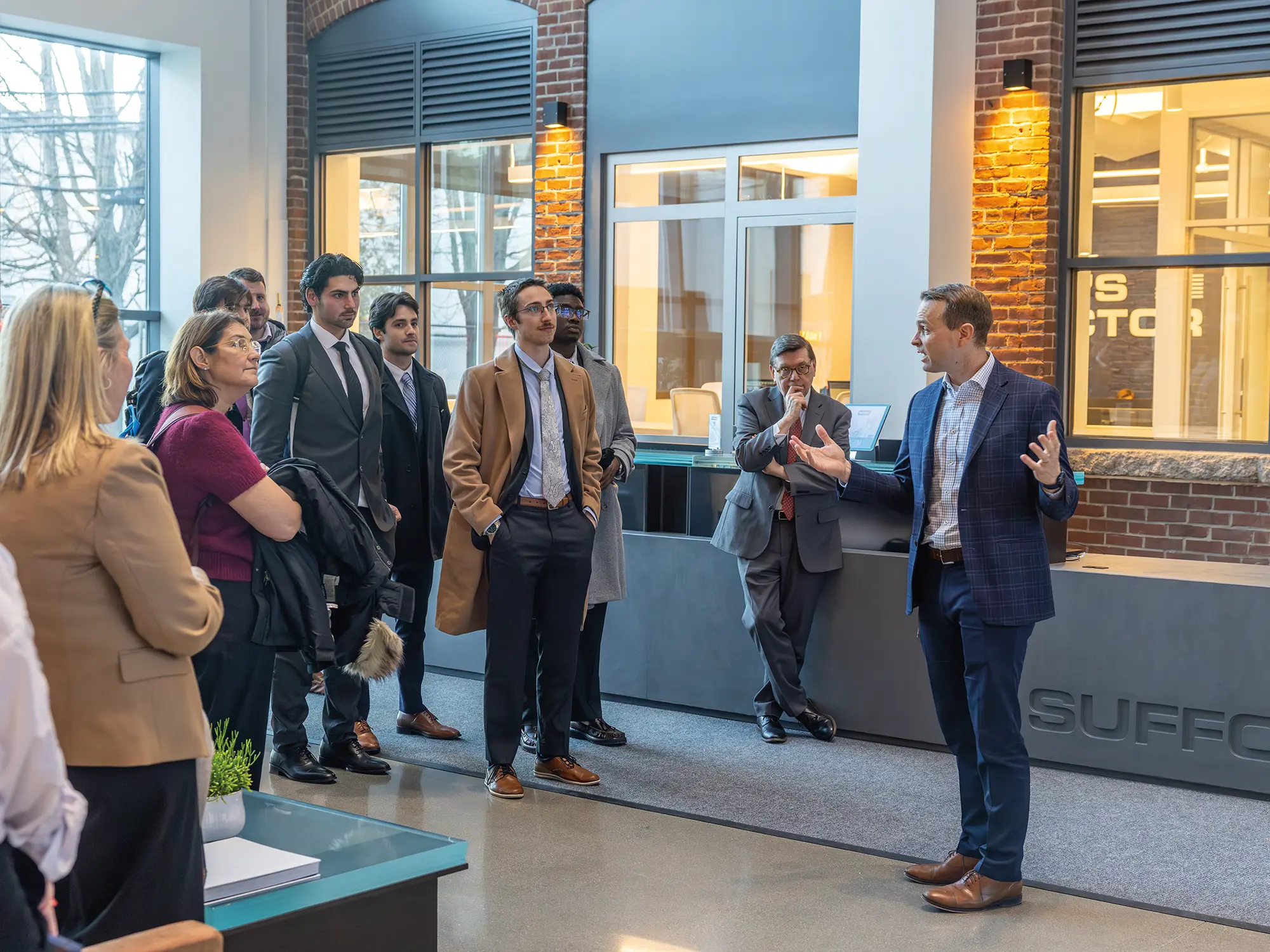 Dan Collier, Head of Red & Blue University at Suffolk Construction, welcomes students and President Mark D. Gearan to the company's headquarters in Boston