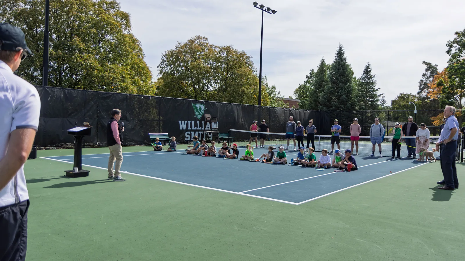 Speakers address families at the dedication of the Grosso Family Tennis Court