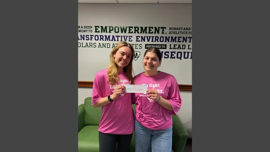 William Smith field hockey student-athletes present a fundraising check