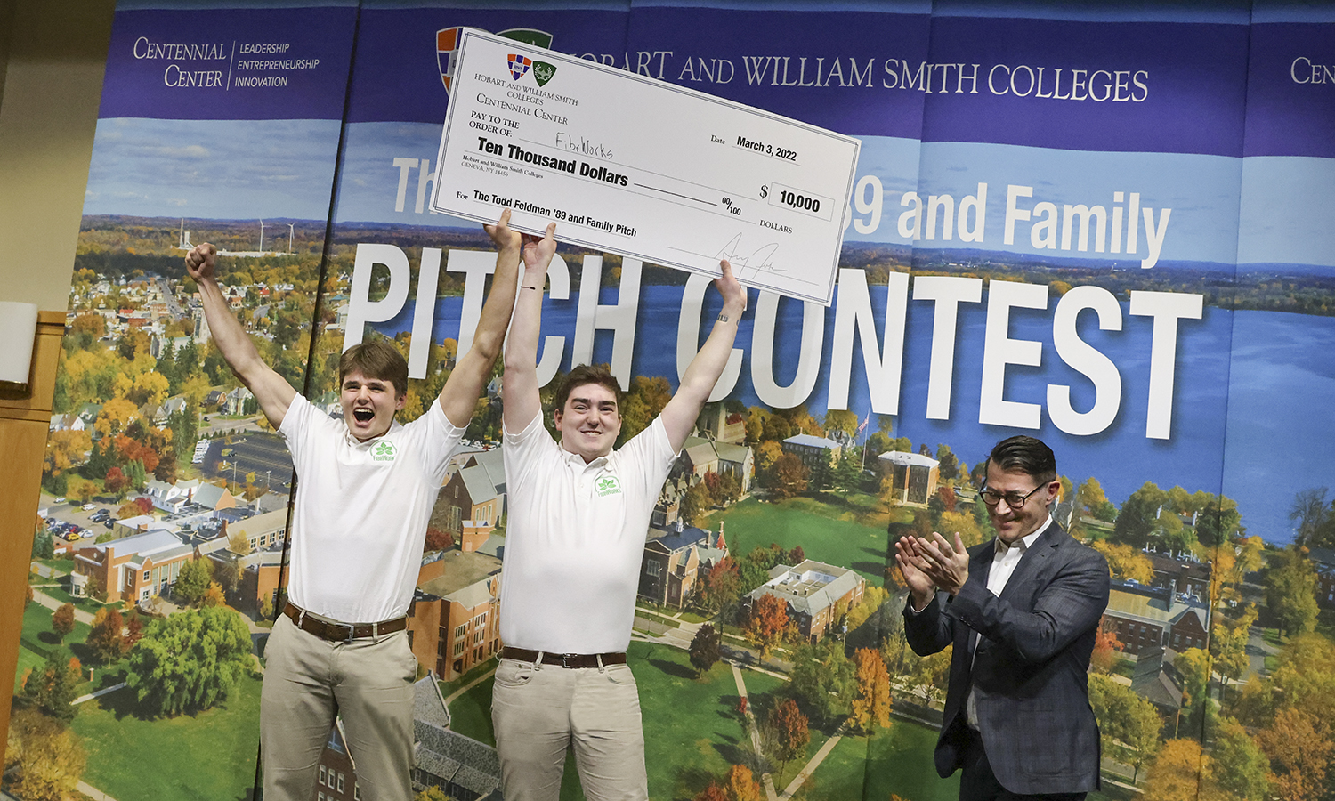 The Pitch winners hoist a check over their heads.