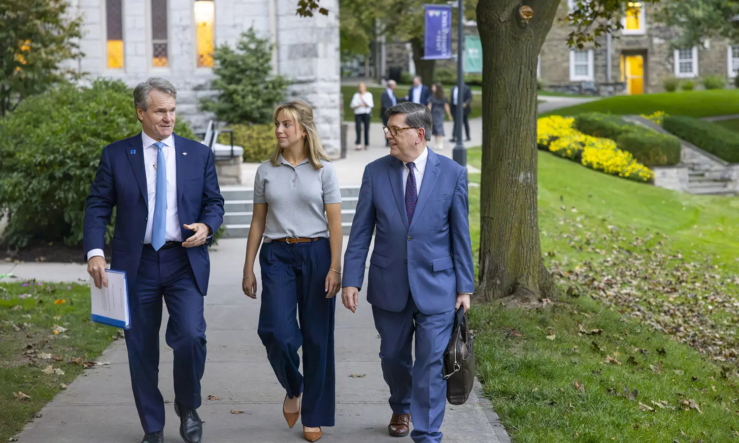 Bank of America CEO Brian Moynihan walks across campus with President Mark D. Gearan and Bank of America new hire Emily Cain ’27. 