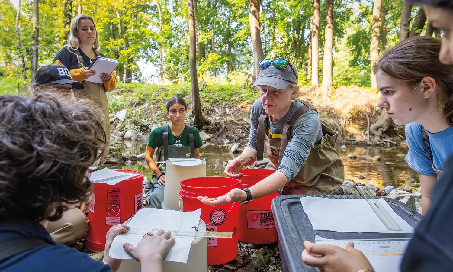 In Castle Creek, Associate Professor of Practice Susan Cushman ’98 shows off a Blacknose Dace to students during an “Ecology” lab.