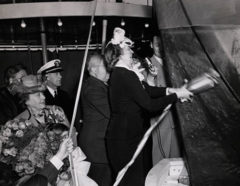 Sen. Tom Connally’s wife swinging a champagne bottle against the prow of the S.S. Hobart Victory during the ship’s launch.
