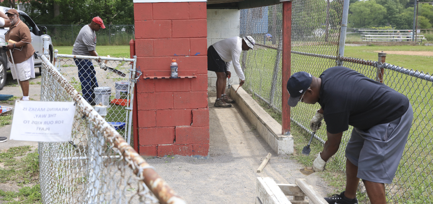 Volunteers paint at the Geneva Little League Field.